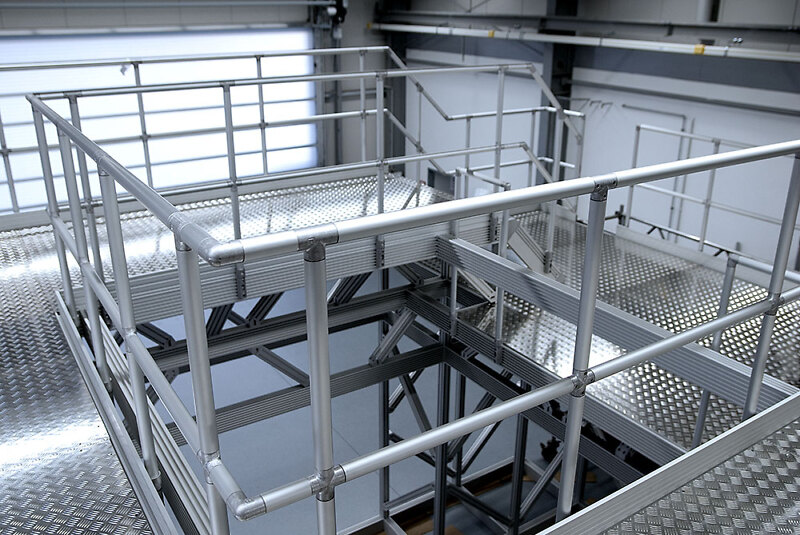 Hohe Arbeitsbühne mit Treppe und Geländer für eine Industrieanlage