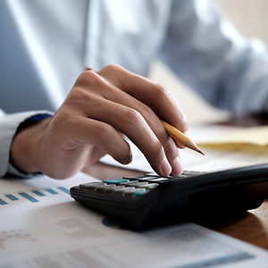 Mann tippt etwas in Taschenrechner