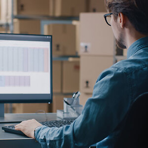 Mann im Lager am Computer